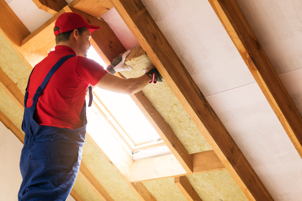 Man installing attic insulation in client home